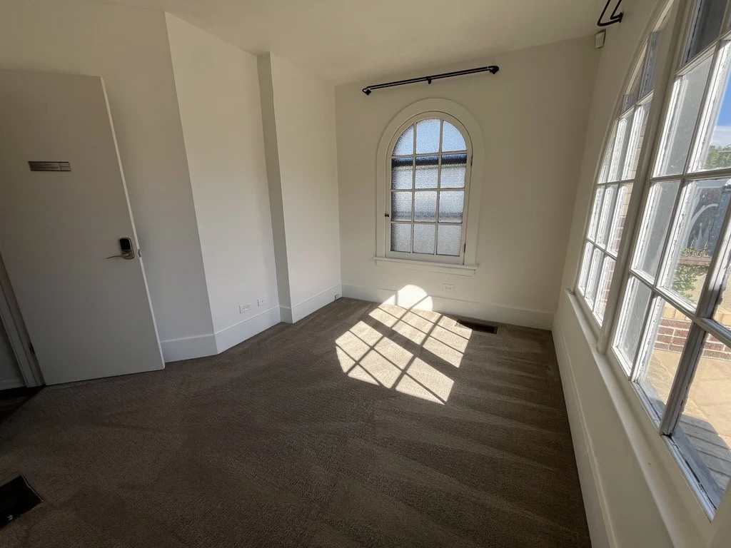 Sunlight falling through arched windows in a private office