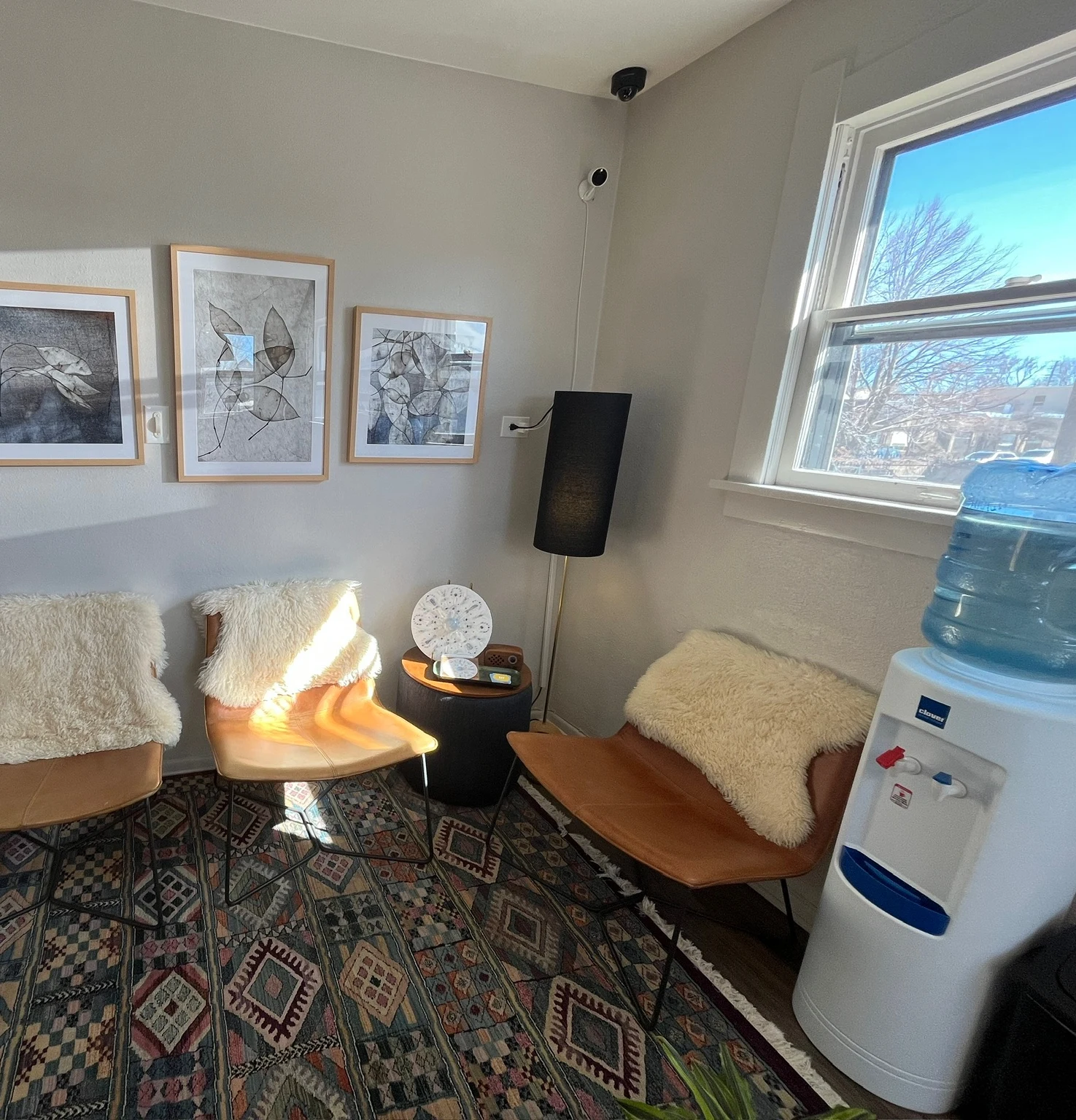 Shared lobby with lounge chairs beside a sunlit window